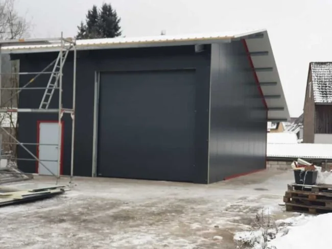 Anbau aus Stahl mit Sektionaltor an bestehendem Gebäude