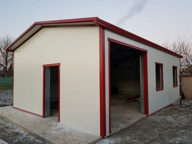Kompakte Halle mit weißer Fassade und roten Kanten