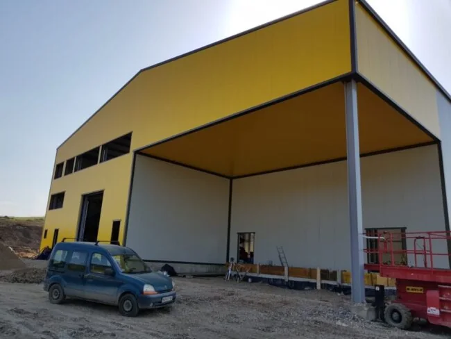 Offene Halle mit gelber Fassade im Aufbau